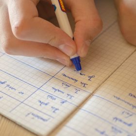 Studente scrive appunti su un quaderno